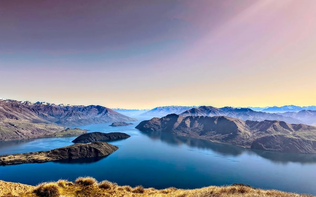 A helicopter over Lake Wanaka with the Southern Alps behind it